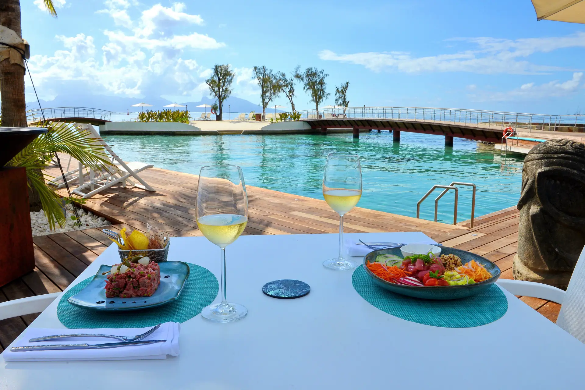 Table dressée au bord du lagon à Tahiti, tartare de thon et poisson cru, Moorea à l'horizon